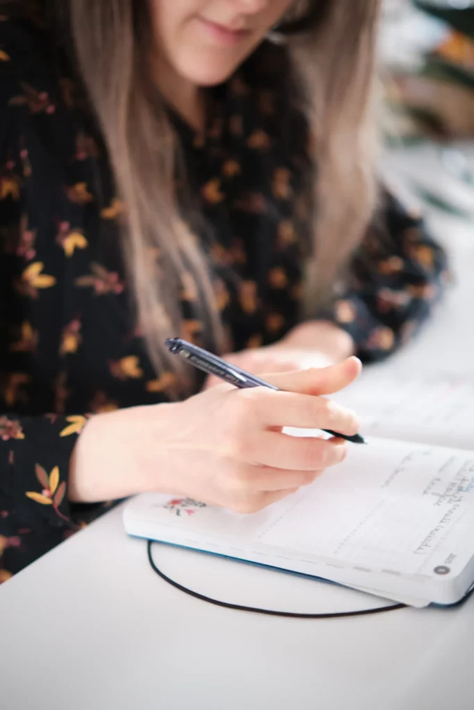 Photo de Maëva Campos, consultante SEO qui note un rendez-vous dans son agenda.